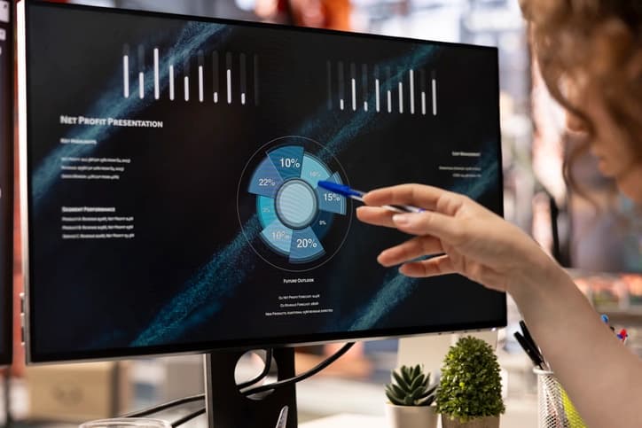 Professional presenting revenue data and analytics on large monitor screen